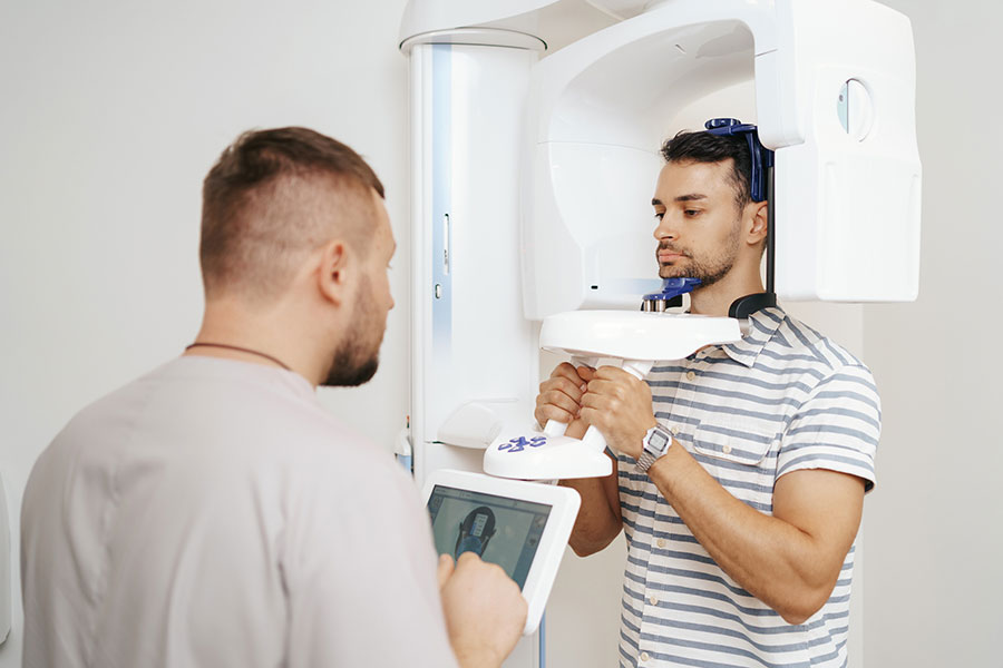 Médico y paciente usando una máquina de rayos x, diagnóstico por computadora tomografía dental